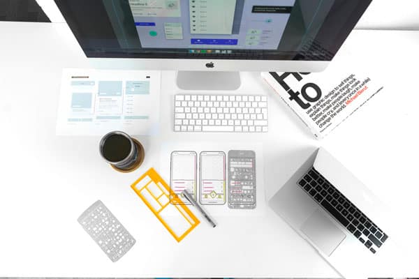 An aerial view of a workspace with an iMac and MacBook Pro
